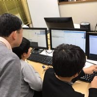 Scratchのプログラミングをしている小学生の男の子2人と一階塾長