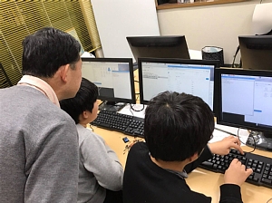 Scratchのプログラミングをしている小学生の男の子2人と一階塾長
