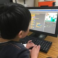 Scratchでアクションゲームを作成している小学生の男の子