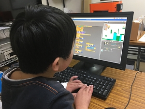 Scratchでアクションゲームを作成している小学生の男の子
