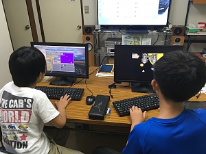 Scratchでシューティングゲームのプログラムを作っている小学生の男の子2人