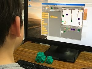 Scratchでゲームをプログラミングしている小学生の男の子